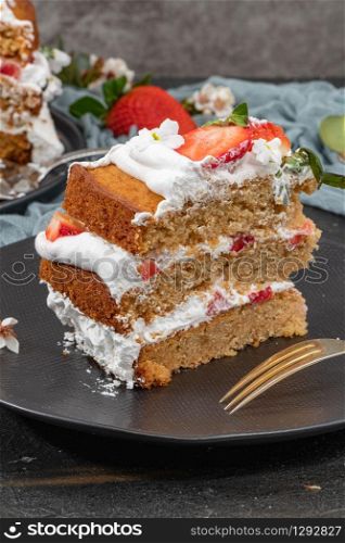 Strawberry cake, strawberry sponge cake with fresh strawberries and sour cream on a dark background