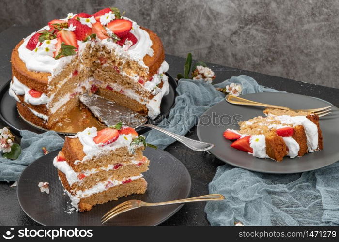 Strawberry cake, strawberry sponge cake with fresh strawberries and sour cream on a dark background