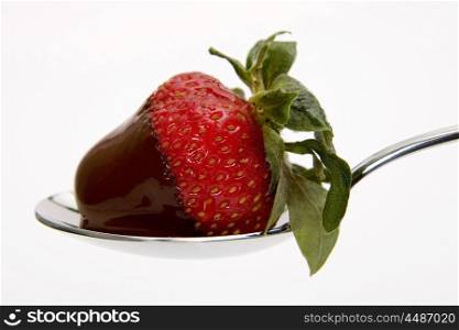 Strawberry covered with chocolate in silver spoon  