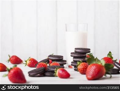 Strawberry dark cookies with glass of milk and fresh berries on wooden background