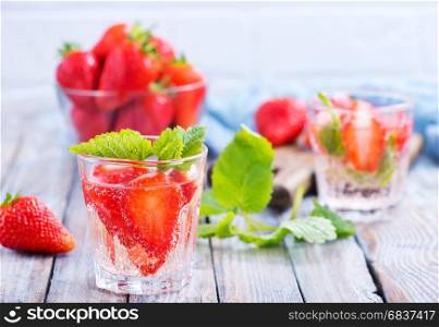 strawberry drink in glass and on a table