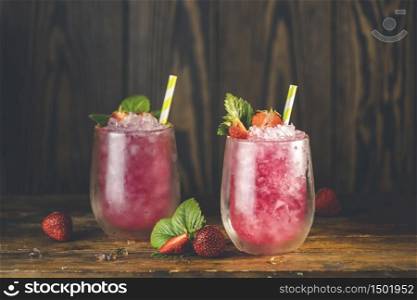 Strawberry drink with ice. Two glass of strawberry ice drink with ripe berry on wooden turquoise table surface. Alcoholic nonalcoholic summer fresh drink beverage