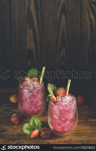 Strawberry drink with ice. Two glass of strawberry ice drink with ripe berry on wooden turquoise table surface. Alcoholic nonalcoholic summer fresh drink beverage