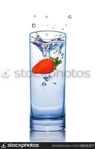 Strawberry dropped into water glass with splash isolated on white
