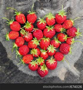 Strawberry Heart shape on old cracked stump, consept love strawberry summer, greeting card. Strawberry Heart shape on old cracked stump