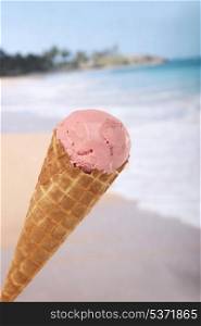 Strawberry ice cream cone with beach in background