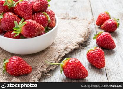 Strawberry in a bowl on wooden background