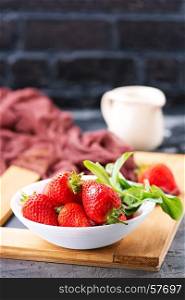 strawberry in bowl and on a table