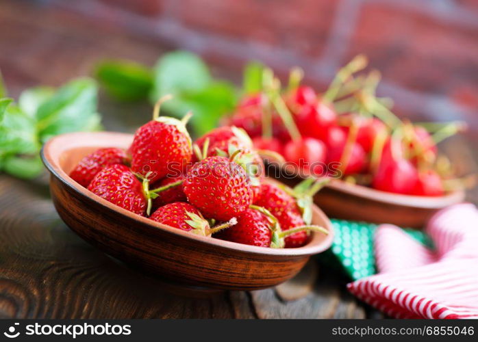 strawberry in bowl and on a table