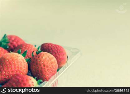 Strawberry in plastic box with copy space, vintage style effect, selective focus