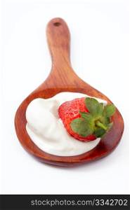 Strawberry in sour cream on a wooden spoon, over white
