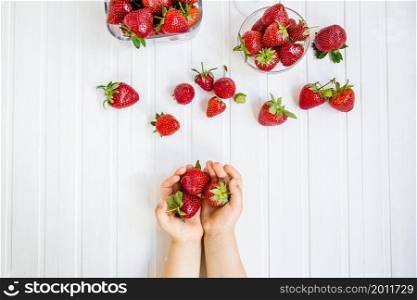 strawberry in the hand of a child on a white background. strawberry in the hand