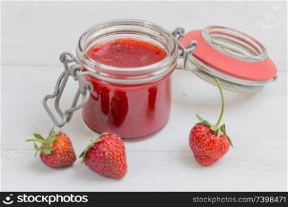 Strawberry jam in a jar on wood.. Strawberry jam in a jar on wood