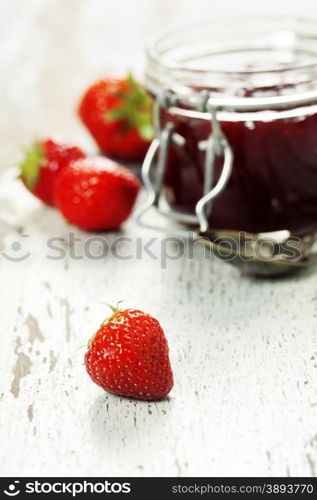 Strawberry jam in a jar on wooden background