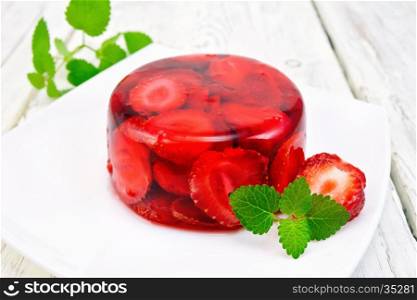 Strawberry jelly with mint and berries in a plate on a kitchen towel on the background light wooden boards