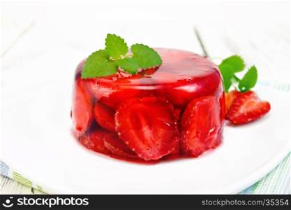Strawberry jelly with mint and berries in a plate on a napkin against the background of wooden boards