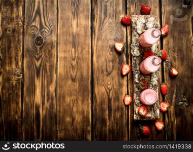 Strawberry juice on a birch tray. On wooden background.. Strawberry juice on a birch tray.