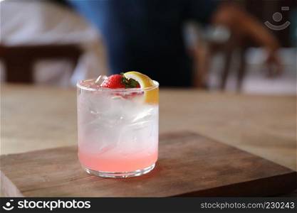 Strawberry juice with soda on wood background