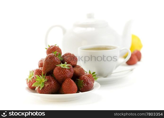 strawberry, lemon, teapot and white teacup with hot tea on white background