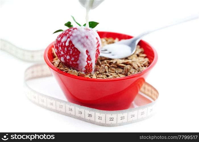 strawberry,milk,fork,measure tape and wheat in a bowl isolated on white