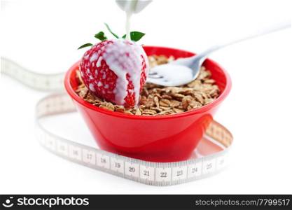 strawberry,milk,fork,measure tape and wheat in a bowl isolated on white