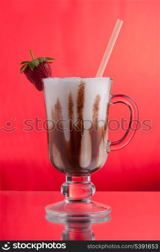 Strawberry milkshake with straw and chocolate on red