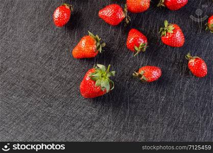 Strawberry pattern on a black background. Fresh strawberries lying on a black background