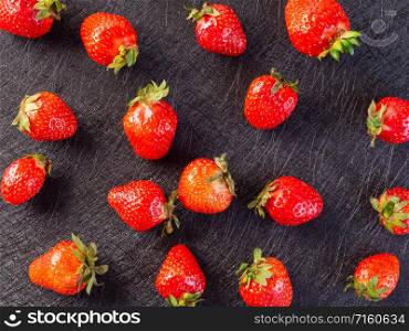 Strawberry pattern on a black background. Pattern of fresh strawberries on a black background