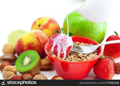 strawberry, peach, apple, kiwi, fork, milk,nuts and wheat in a bowl isolated on white