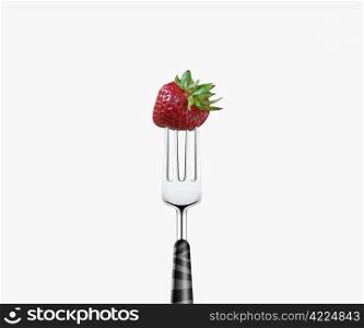 strawberry pierced by fork, isolated on white background
