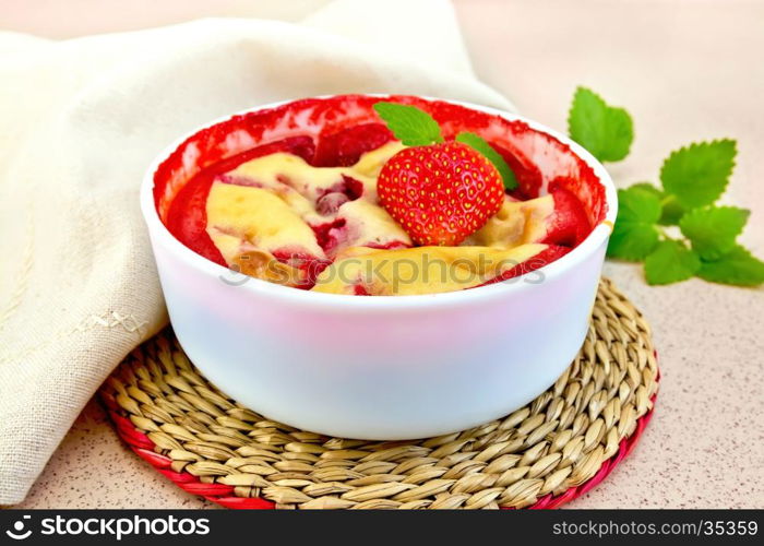 Strawberry pudding in a bowl with berries and mint, napkin against the background of a granite table