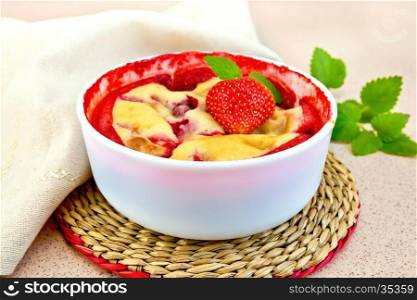 Strawberry pudding in a bowl with berries and mint, napkin against the background of a granite table