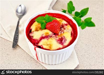 Strawberry pudding in a high bowl with berries and mint on a napkin on a background granite table