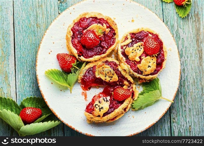Strawberry shortcake pies on the plate.Tasty tartlets with fresh strawberries.Sweet dessert. Summer tartlets with strawberries