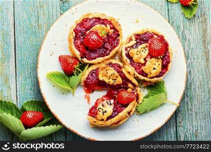 Strawberry shortcake pies on the plate.Tasty tartlets with fresh strawberries.Sweet dessert. Summer tartlets with strawberries