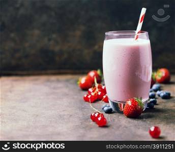 Strawberry smoothie and fresh berry on rustic background