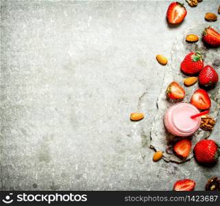 Strawberry smoothie with milk and nuts. On the stone table.. Strawberry smoothie with milk and nuts.
