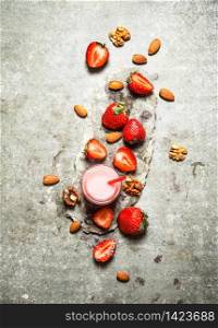 Strawberry smoothie with milk and nuts. On the stone table.. Strawberry smoothie with milk and nuts.