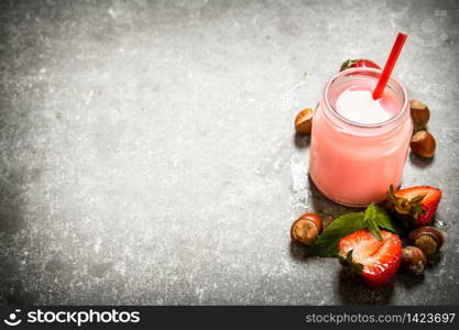 Strawberry smoothie with milk and nuts. On the stone table.. Strawberry smoothie with milk and nuts.