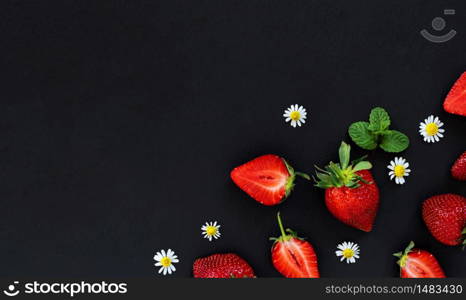 Strawberry, whole and cut to the right on a black stone background, with copy space for text. Top view, dessert cooking concept