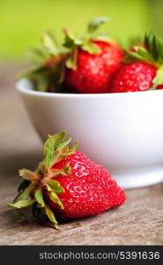 Strawberry with bowl on wooden table outdoor