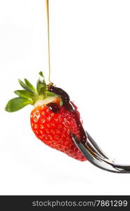 Strawberry with caramel syrup on a fork