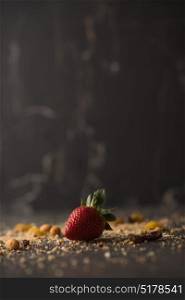 Strawberry with crumbs on dark stone background with copyspace