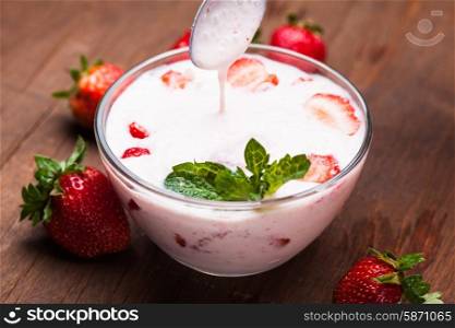 Strawberry yoghurt in a bowl on the table. Strawberry yoghurt