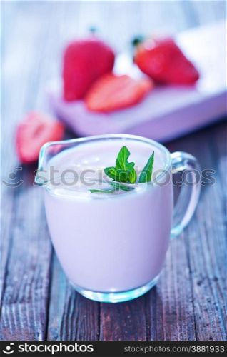 strawberry yogurt in glass jug and on a table
