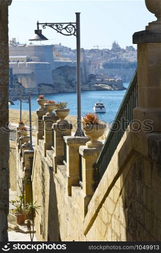 Street along the wall of fortress leading to the sea on the island of Malta in historical part of Valletta.