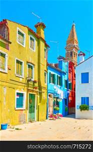 Street and the leaning bell tower of St. Martin's Church in the background in Burano Island, Venice, Italy