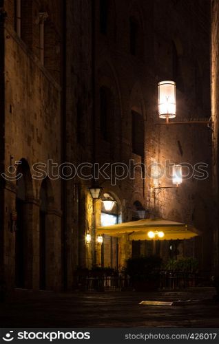 Street Cafe at the old town San Gimignano in evening time at the province of Siena. Tuscany, Italy