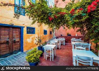 Street cafe in scenic picturesque streets of Chania venetian town with coloful old houses. Chania greek village in the morning. Chanica, Crete island, Greece. Scenic picturesque streets of Chania venetian town. Chania, Creete, Greece