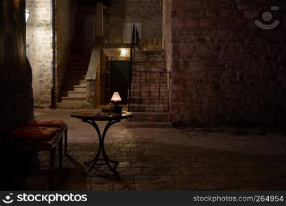Street cafe table at night. Old European city view